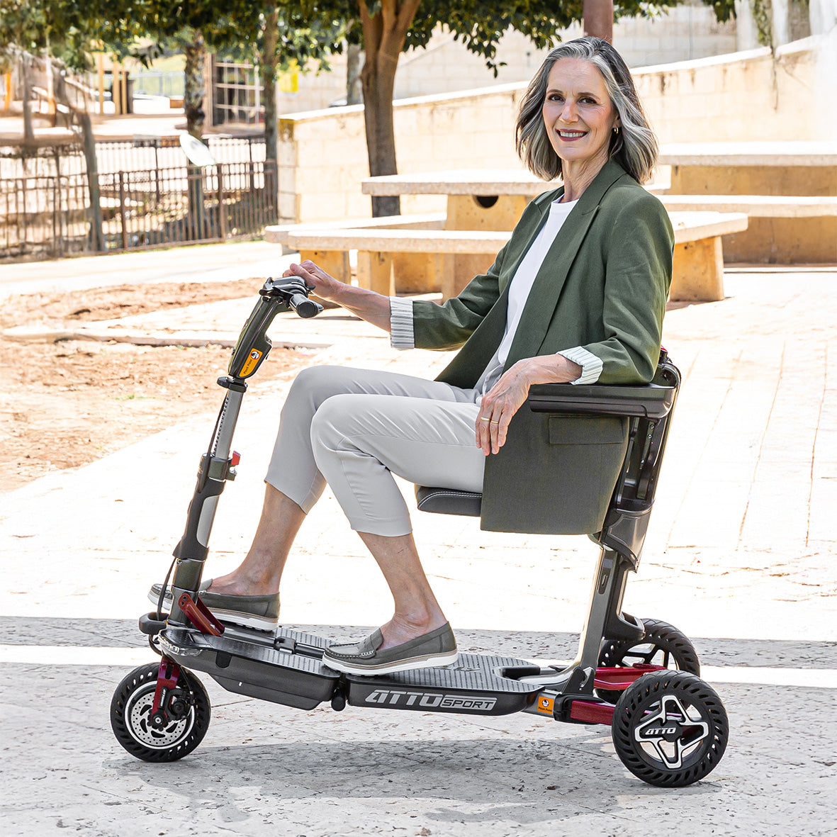 אישה אלגנטית נהנית מעצמאות ומתניידת בביטחון על קלנועית מתקפלת מדגם ATTO SPORT במרחב הציבורי.